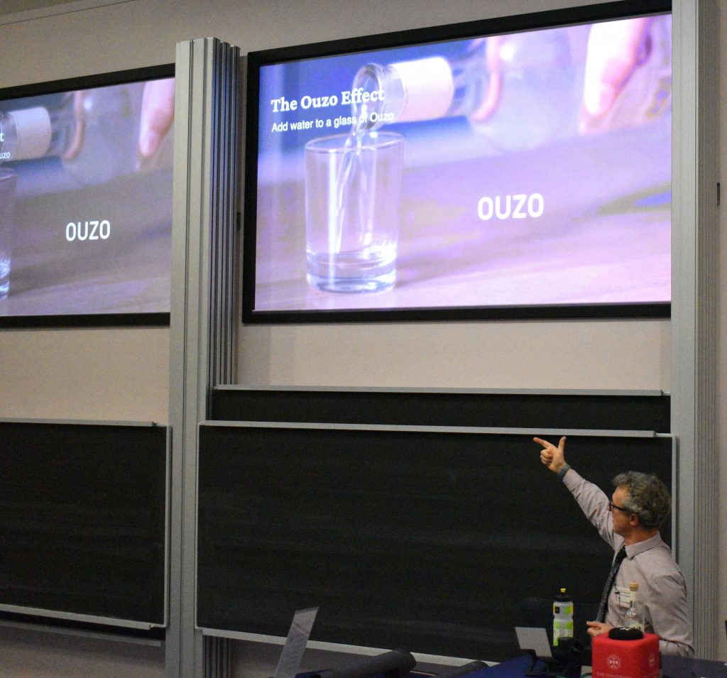 Dave Fairhurst is in front of a whiteboard, presenting slides on some of his recent work.