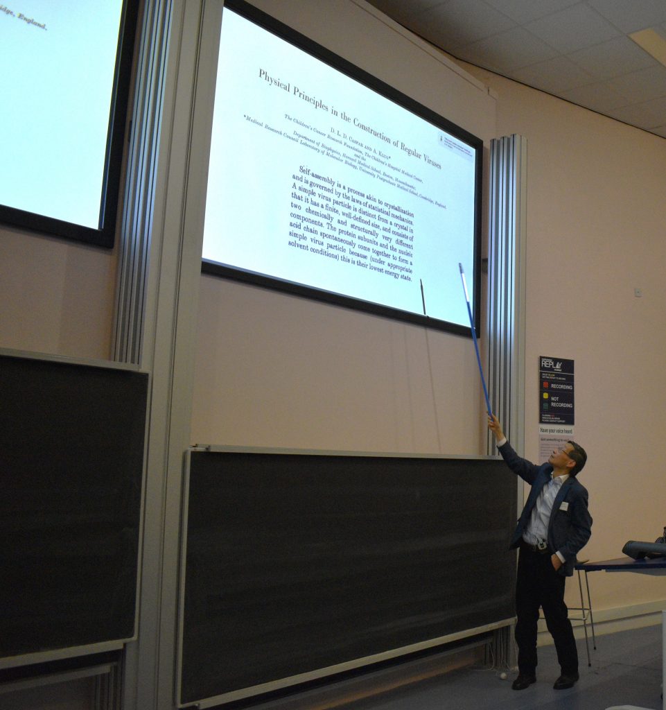 Professor Wilson Poon is in front of a whiteboard presenting some of his science.