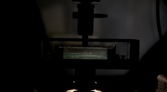 A universal testing machine compresses a laminate system.