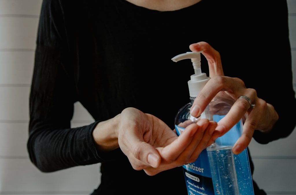 A person is using a bottle of hand sanitiser to clean their hands.